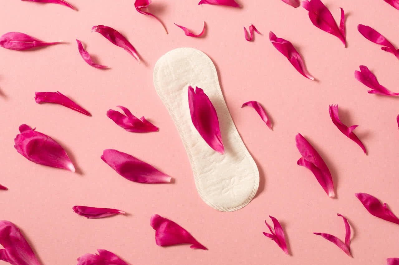 Imagem de uma cartela de Clomid ao lado de um calendário menstrual.